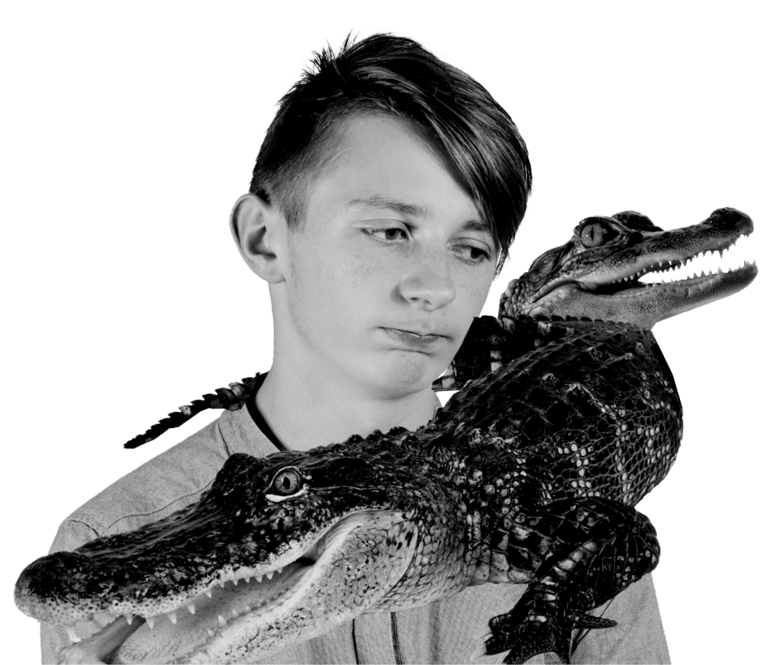 young boy sadly looking towards a gator